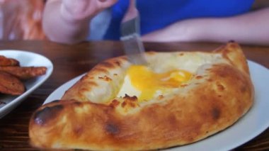Acara Khachapuri bir çatal ile ahşap bir masa üzerinde bir Gürcü restoranda yemek kadın. Gürcü gıda