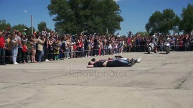 Yalan insanlar aracılığıyla trambolin üzerinde motosiklet atlama. Moto hüner. Dublör Moto Show. Ağır çekim