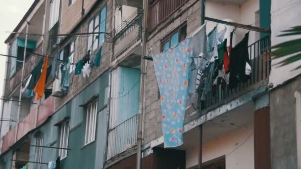 La ropa pesa y se seca con una cuerda en un edificio de varios pisos en un barrio pobre de la ciudad. Moción lenta — Vídeos de Stock