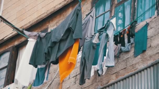 Ρούχα ζυγίζουν και στεγνώνουμε με ένα σχοινί σε ένα πολυώροφο κτίριο σε μια φτωχή γειτονιά της πόλης. Αργή κίνηση — Αρχείο Βίντεο