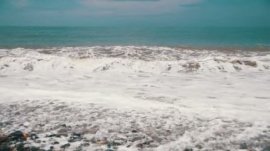 Deniz fırtınası. Dalgalar bir çakıl taşı kumsalda gürüldüyor. Ağır çekim