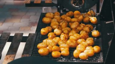 Genç patatesler ızgarada hazır olsun. Barbeküde patates döndürmek için maşa kullanıyorum.