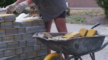 İşçi el arabası içinde renkli bir kaldırım taşı yükler