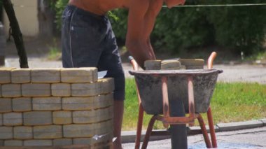 İşçi el arabası içinde renkli bir kaldırım taşı yükler