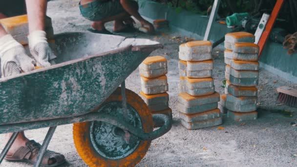 Het bouwproces, herstellen van de stoep. Werknemer leggen steen bestrating in een stad Park — Stockvideo