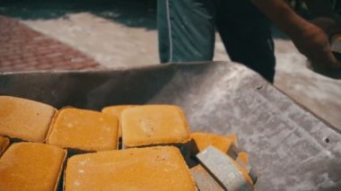 Şantiye, inşaat işçisi kaldırır taş parke gelen el arabası. Ağır çekim