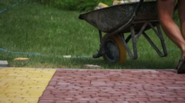 İnşaat işçisi bir inşaatta kaldırım taşları ile bir el arabası kullanıyor. Ağır çekim