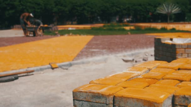 El proceso de construcción, la reparación de la acera. Pavimento de piedra de colocación de trabajador en un parque de la ciudad — Vídeos de Stock