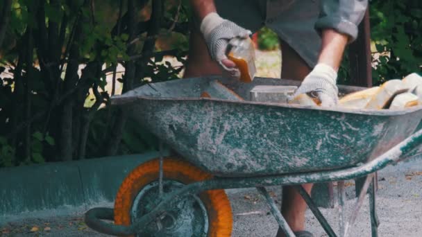 Pracovník načte barevné dlažební vozí na trakaři