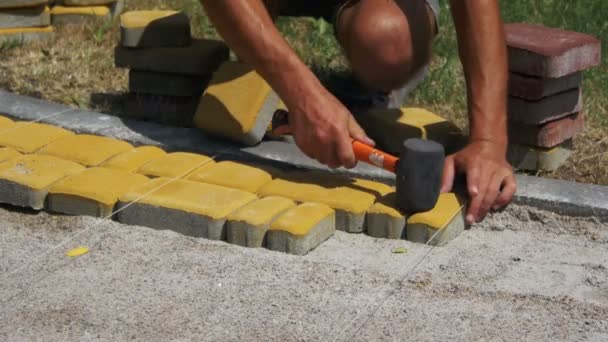 O construtor está colocando pedras de pavimentação — Vídeo de Stock