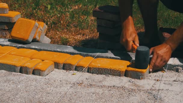 De bouwer is leggen van straatstenen — Stockvideo