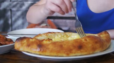 Acara Khachapuri bir çatal ile ahşap bir masa üzerinde bir Gürcü restoranda yemek kadın. Gürcü gıda