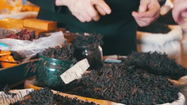 Люди выбирают сырой чай в мешках на спонтанном рынке — стоковое видео