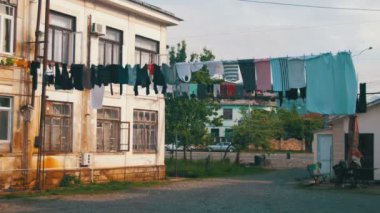 Giysi tartmak ve şehrin yoksul bir mahallede bir çok katlı binada bir ip üzerinde kuru