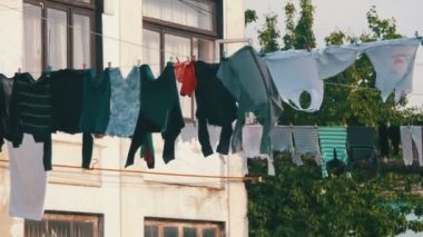 Giysi tartmak ve şehrin yoksul bir mahallede bir çok katlı binada bir ip üzerinde kuru