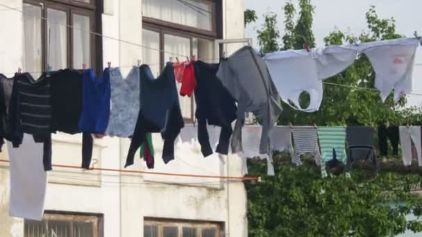 La ropa pesa y se seca en una cuerda en un edificio de varios pisos en un barrio pobre de la ciudad — Vídeo de stock