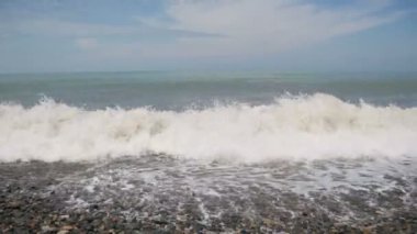 Deniz fırtınası. Dalgalar bir çakıl taşı kumsalda haddeleme.