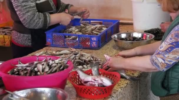 Vrouw vis verkoper reinigt en snijden van verse vis op de vismarkt — Stockvideo