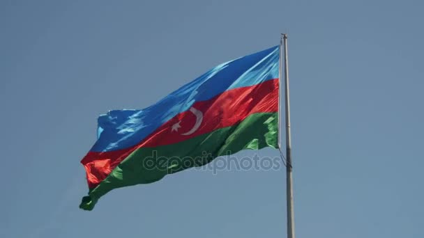 Bandera de Azerbaiyán en el asta de la bandera ondeando en el viento contra el cielo azul — Vídeo de stock