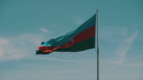 Σημαία του Αζερμπαϊτζάν σχετικά με το κοντάρι σημαίας που κυματίζει στον αέρα ενάντια στον γαλάζιο ουρανό — Αρχείο Βίντεο