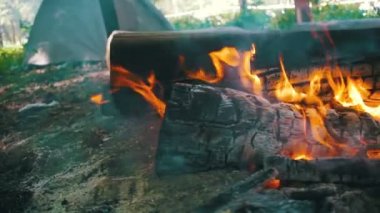 Bir çadır kamp içinde şenlik ateşi Burns ve ormanda günlüğe kaydeder. Ağır çekim