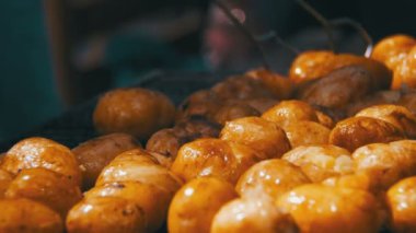Genç patatesler ızgarada hazır olsun. Barbeküde patates döndürmek için maşa kullanıyorum.
