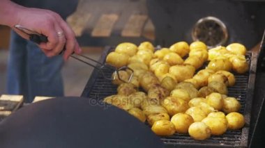 Yavaş çekimde bir ızgarada genç patates hazırlamak