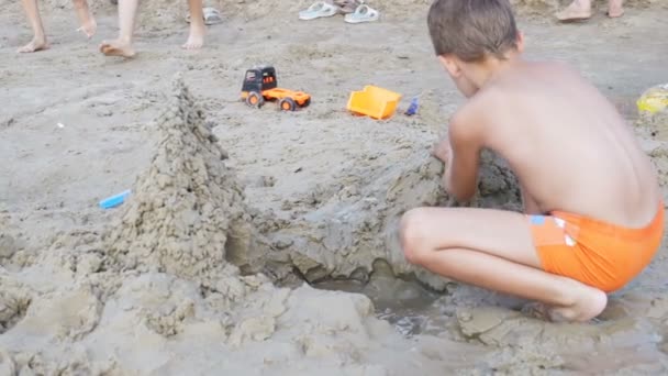 Kind baut in Zeitlupe eine Sandburg am Strand — Stockvideo