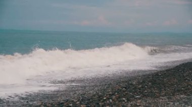 Deniz fırtınası. Dalgalar bir çakıl taşı kumsalda gürüldüyor. Ağır çekim