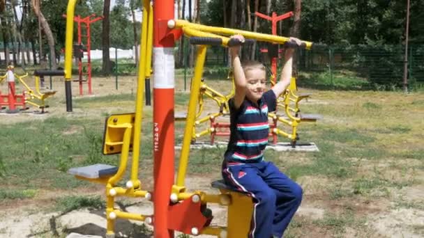 Enfant engagé dans un équipement d'entraînement sportif de rue — Video