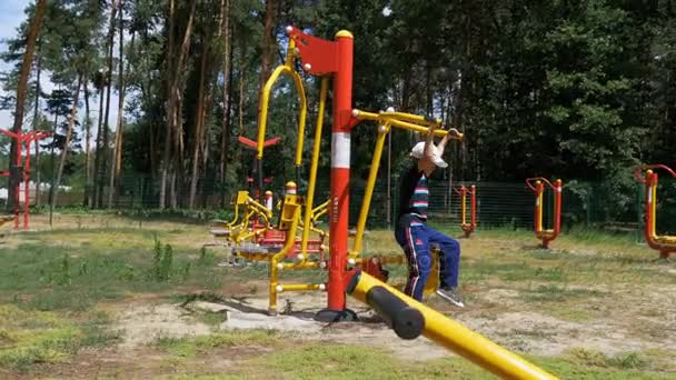 Enfant garçon engagé dans un simulateur d'entraînement sportif dans la rue — Video