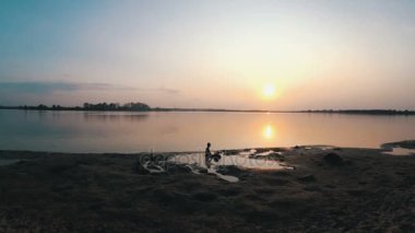 Küçük çocuk yapılar bir kum kale günbatımında siluet