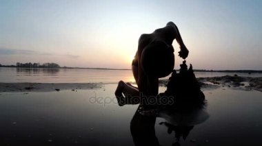 Küçük çocuk yapılar bir kum kale günbatımında siluet