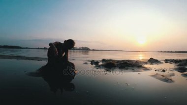 Sahilde günbatımı kum kale inşa bir çocuk silüeti