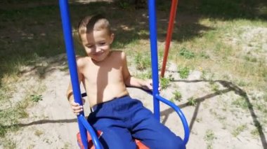 Yavaş çekimde bir salıncak üzerinde sallanan mutlu küçük çocuk çocuk