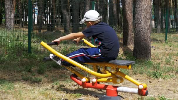 Enfant engagé dans un équipement d'entraînement sportif de rue — Video