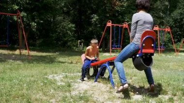 Mutlu çocuk çocuk ve onun anne Swinging Street denge Swing Bahçesi ağır çekimde, Tarih