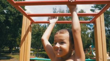 Genç çocuk demirlere tarafından ellerini gökyüzüne ağır çekimde karşı açık Bahçesi, egzersiz için bekle