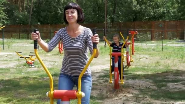 Moeder en zoon op straat fitnessapparaten gaan voor sport in Slow Motion — Stockvideo