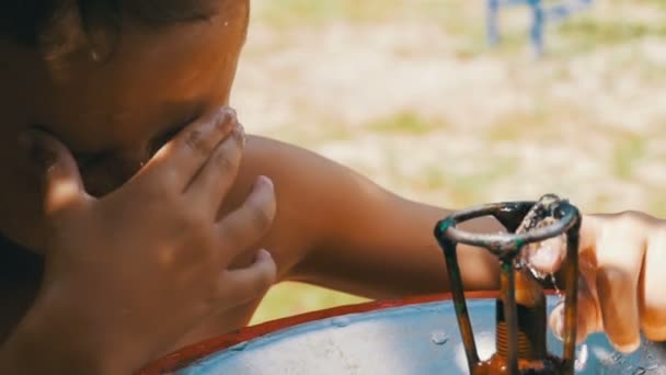 Feliz niño divertido agua potable de una fuente de agua potable en el patio de recreo en cámara lenta — Vídeo de stock