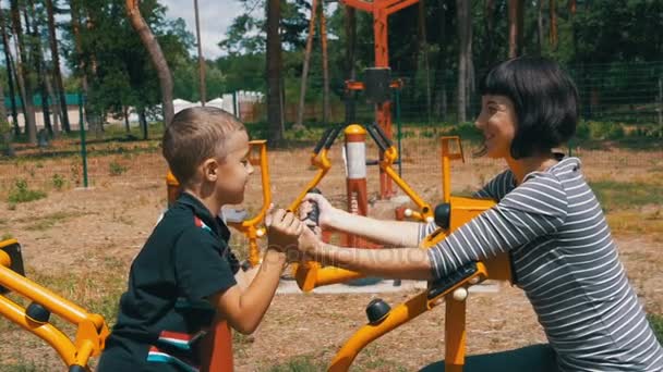 Madre e hijo en simuladores de entrenamiento deportivo participan en deportes en cámara lenta — Vídeo de stock