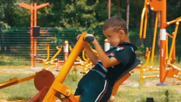 Enfant garçon engagé dans un simulateur d'entraînement sportif dans la rue au ralenti — Video