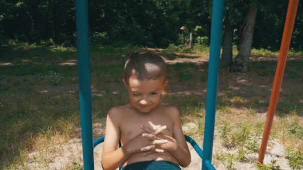 Glad liten unge pojke svänga på en gunga i Slow Motion — Stockvideo