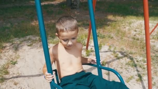 Happy Little Kid Boy Swinging on a Swing in Slow Motion — Stock Video