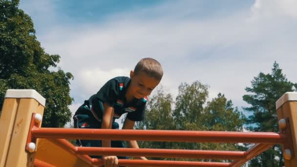 子供がスローモーションで青空段違い平行棒にある遊技場で遊ぶ — ストック動画