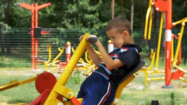 Enfant garçon engagé dans un simulateur d'entraînement sportif dans la rue au ralenti — Video