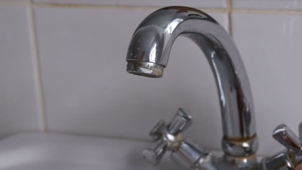 Aprire il rubinetto e il flusso di acqua versando dal rubinetto cromato — Video Stock