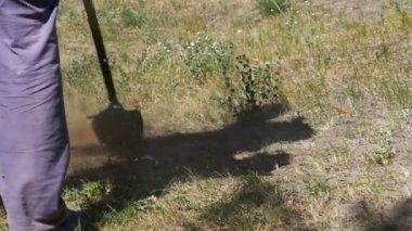 Adam Mows yavaş çekimde taşınabilir bir çim biçme makinesi kullanarak çimen