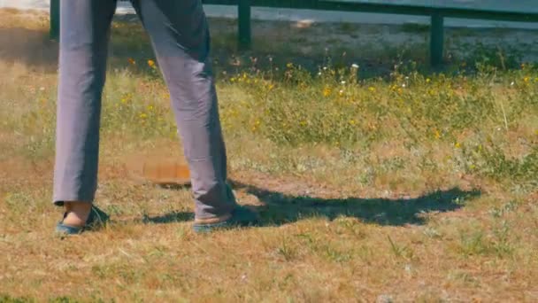 Trädgårdsmästare klipper gräset med en bärbar gräsklippare — Stockvideo