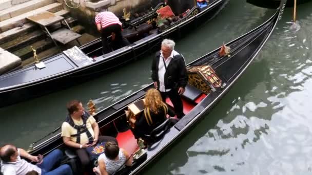 Gondoler med turister simma längs en smal kanal i Venedig Street, Italien — Stockvideo